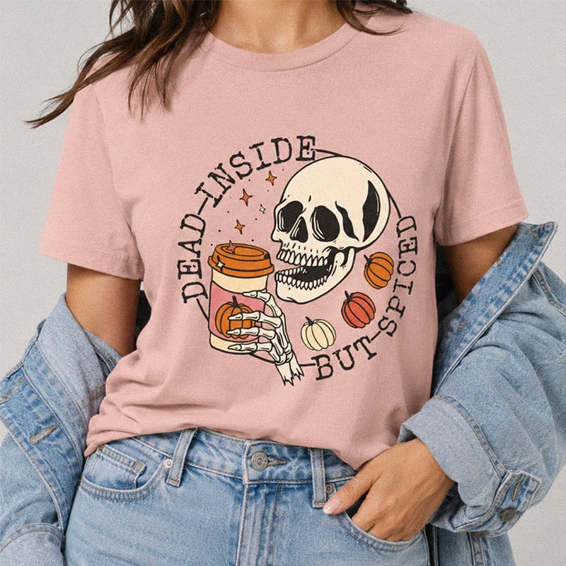 Woman wearing a peach Dead Inside But Spiced Shirt - Funny Halloween Graphic Tee featuring a skull holding a pumpkin spice latte with pumpkins and the text "Dead Inside But Spiced"