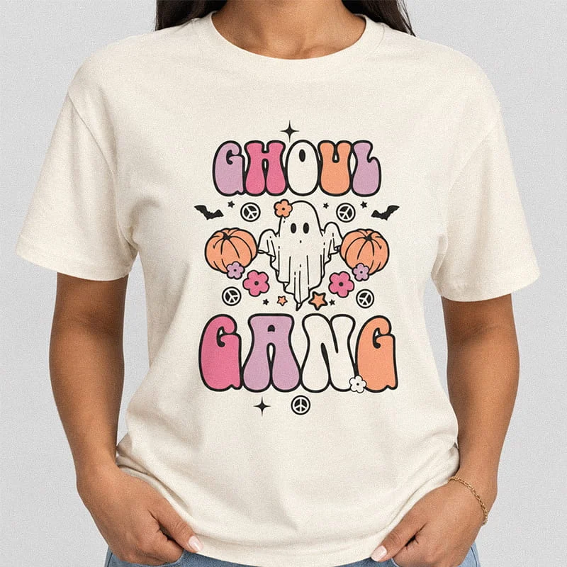 Woman wearing an natural color Ghoul Gang Halloween T-Shirt - Cute Ghost Graphic Tee with a peace-sign ghost, pumpkins, flowers, and typography