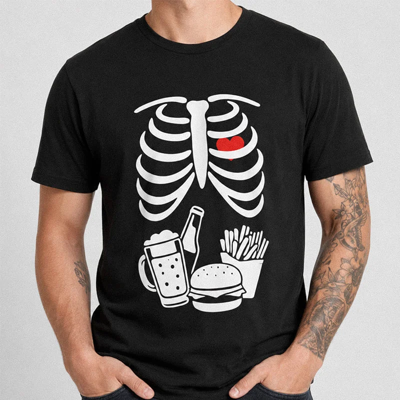 Man wearing a black Matching Halloween Pregnancy Announcement Shirt For Him - Skeleton Couples T-Shirt featuring an X-ray ribcage with a heart, burger, beer, and fries