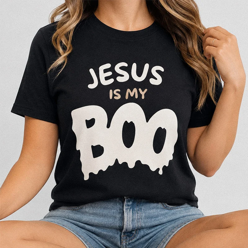 Woman wearing a black Jesus Is My Boo Funny Christian Halloween Tee - Faith-Inspired Fall Shirt featuring groovy dripping typography reading Jesus Is My Boo