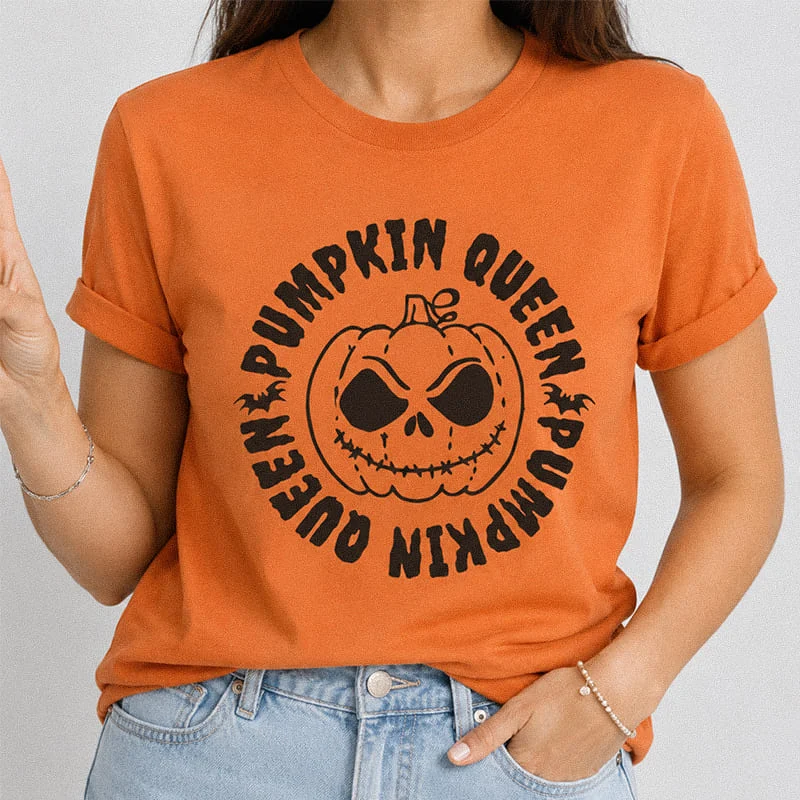 Woman wearing an orange Pumpkin Queen Shirt – Spooky Halloween Pumpkin Tee featuring a creepy jack-o'-lantern pumpkin face surrounded by circular text reading Pumpkin Queen