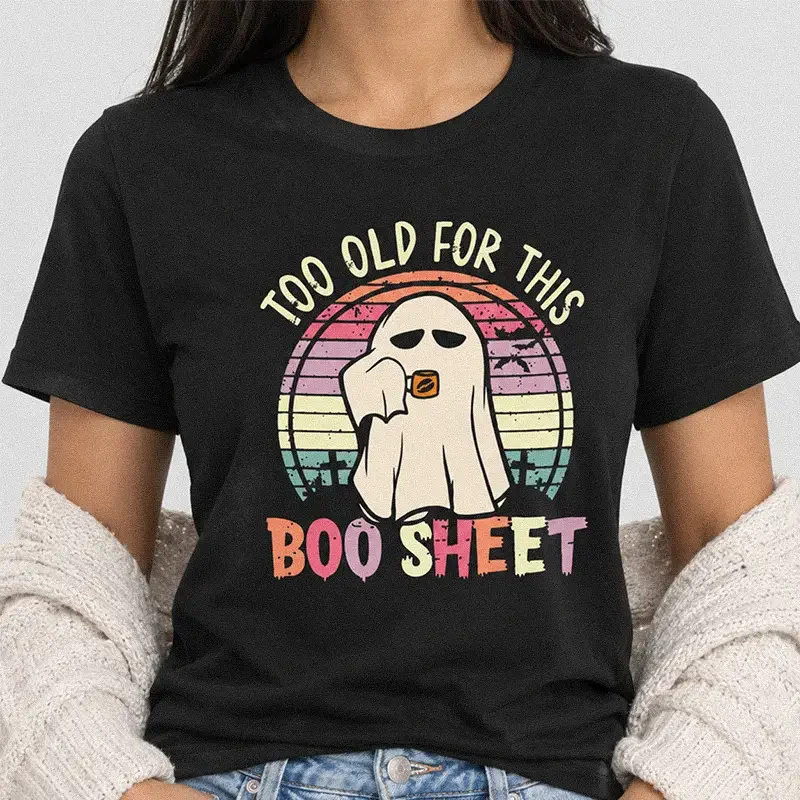 Woman wearing a black Too Old for This Boo Sheet Shirt - Funny Ghost Halloween Tee featuring a tired ghost drinking coffee