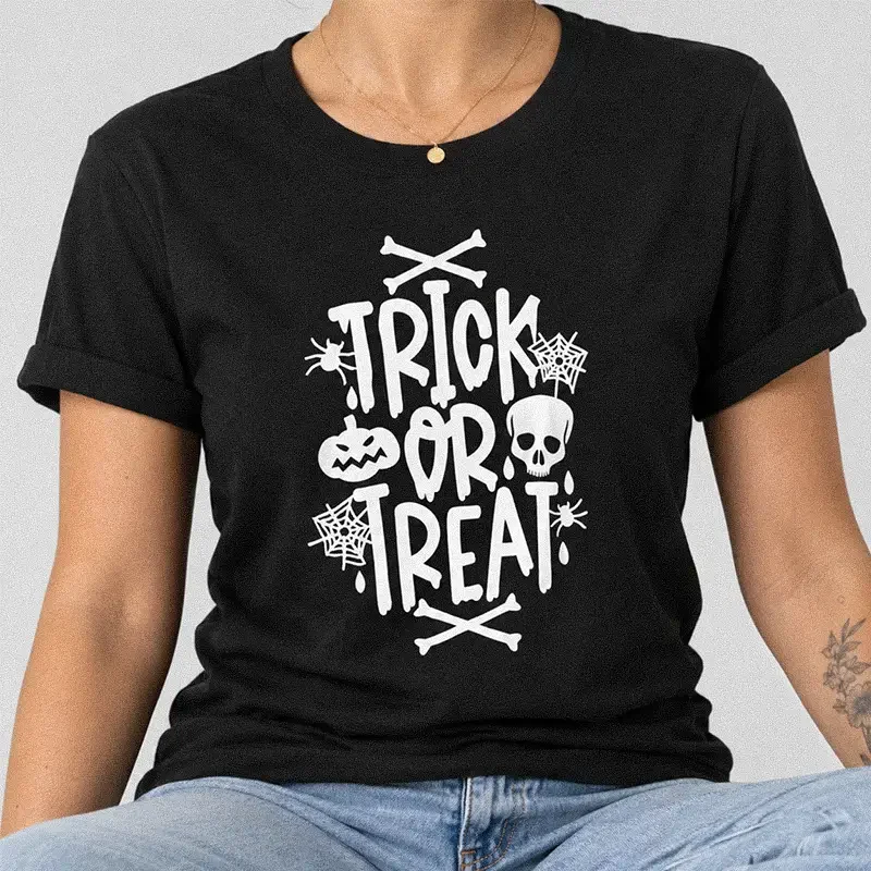 Woman wearing a black Trick or Treat Shirt - Classic Halloween Graphic Tee with skull, spider, and pumpkin graphics