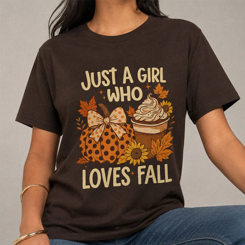Woman wearing a brown Just a Girl Who Loves Fall Shirt - Pumpkin Spice Autumn Tee featuring a polka dot pumpkin, iced coffee, sunflowers, and autumn leaves with text reading "Just A Girl Who Loves Fall"