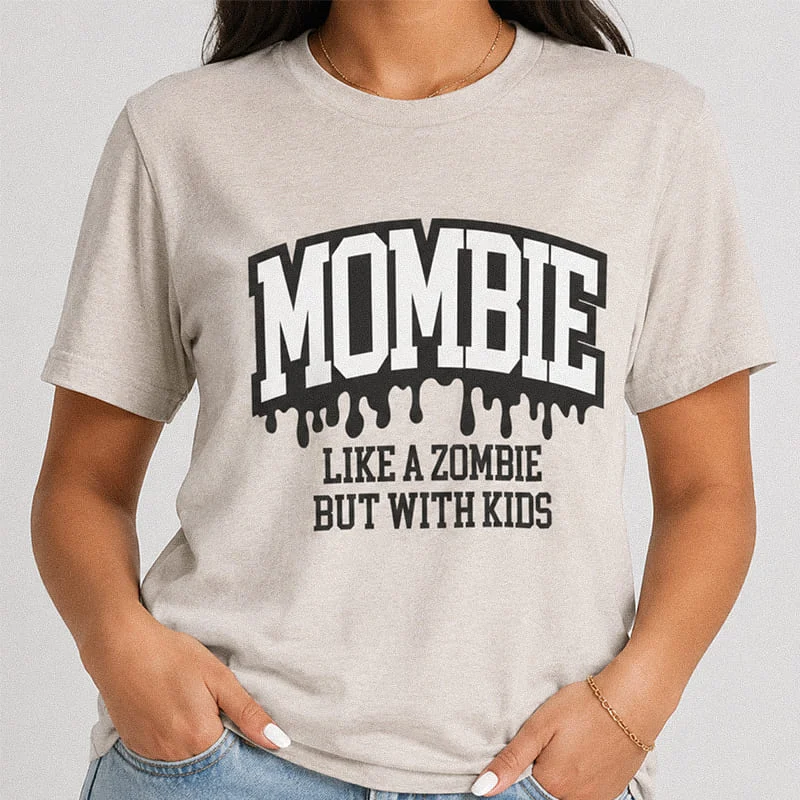 Woman wearing a heather grey funny heather dust Mombie Like a Zombie But With Kids Shirt - Mombie Funny Mom Halloween Tee reading Mombie Like A Zombie But With Kids