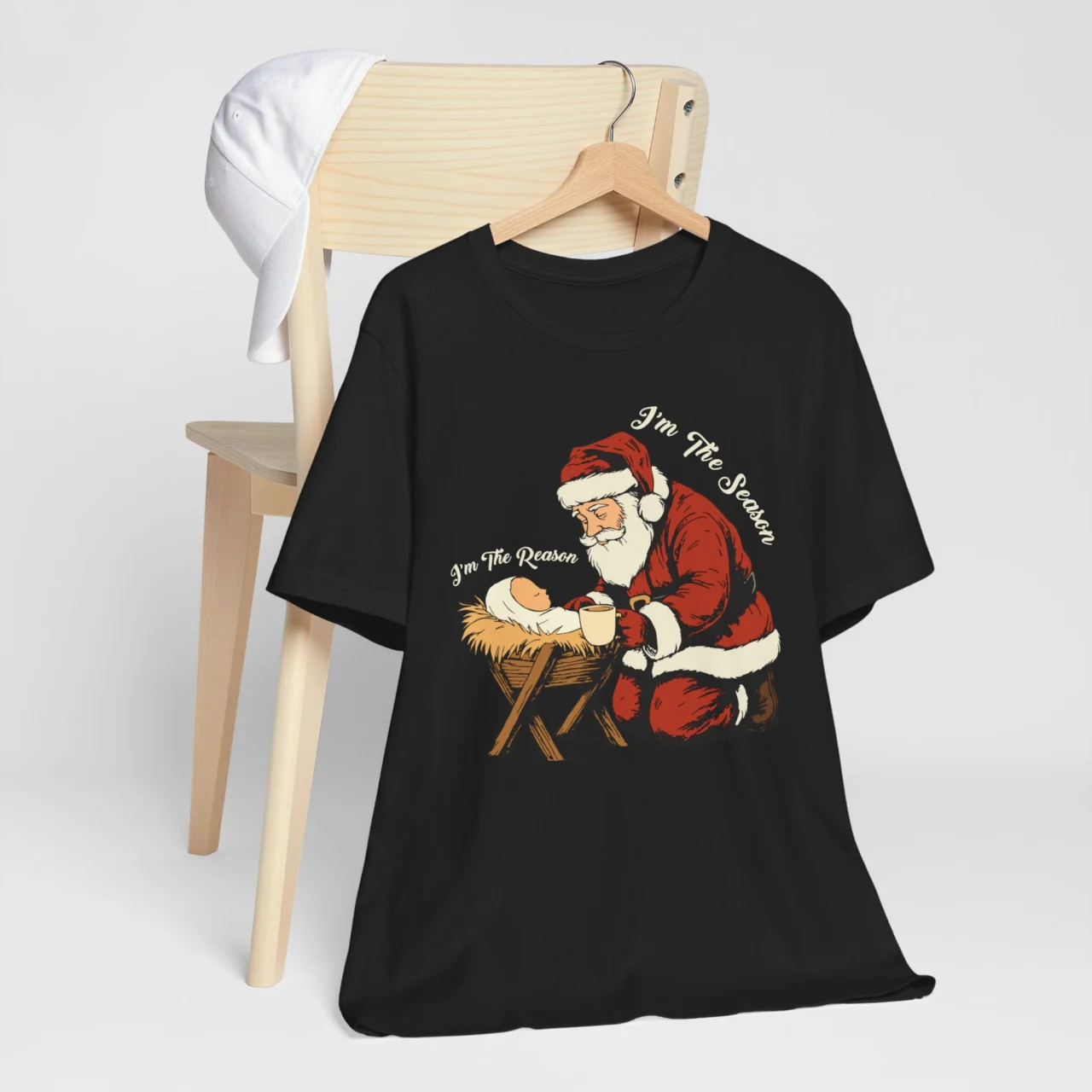I'm the Reason I'm the Season Shirt with vintage Santa kneeling before Baby Jesus and the text 'I'm The Season', a Funny Sarcastic Christmas Nativity Tee.