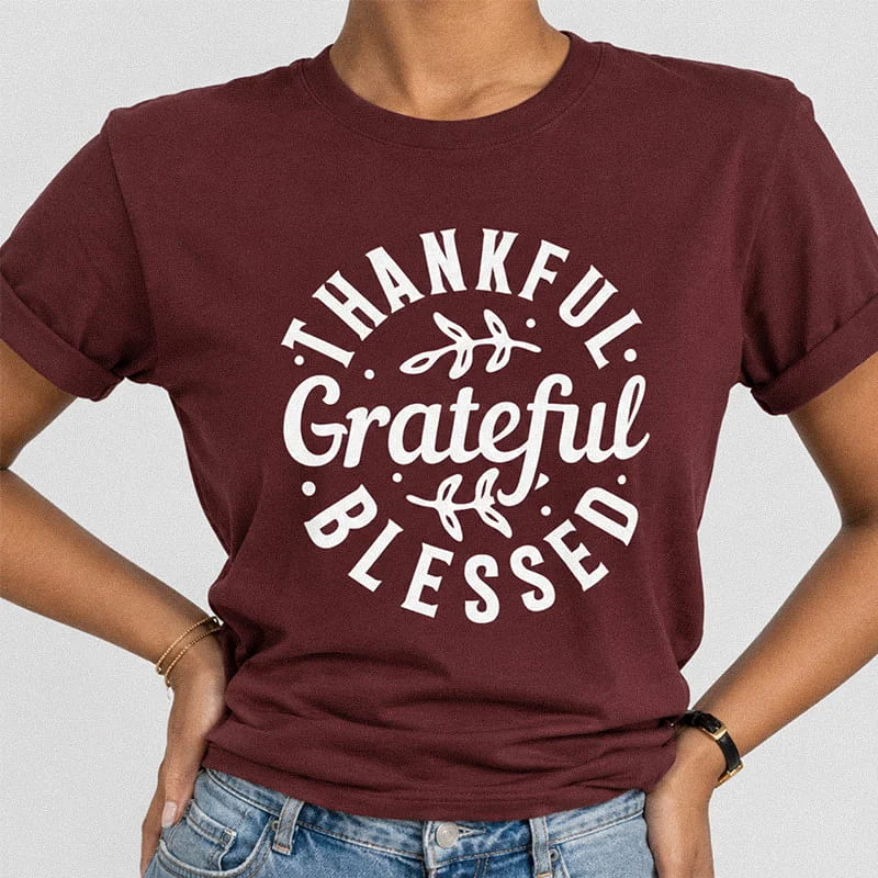 Woman wearing a maroon Thankful Grateful Blessed Shirt - Thanksgiving Gratitude Tee featuring white circular typography reading Thankful Grateful Blessed with leaf accents.