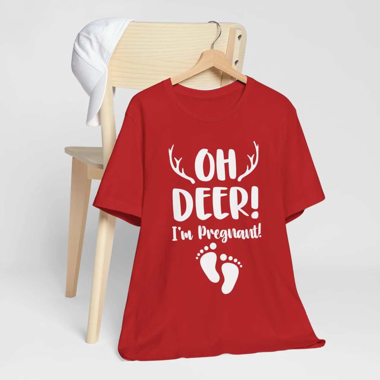 Oh Deer I'm Pregnant Shirt in red with white antlers and baby footprints, a Christmas Pregnancy Announcement Tee design.