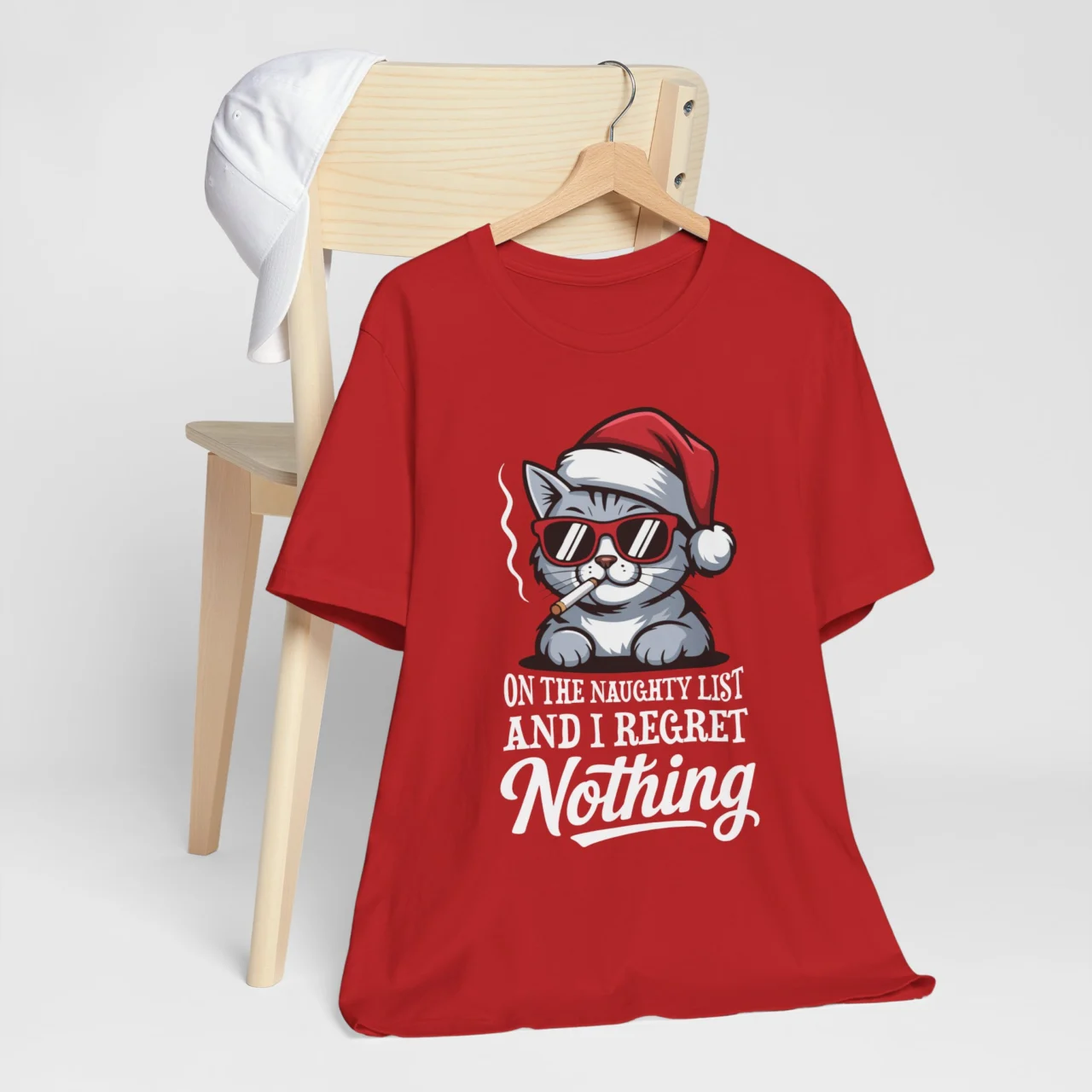 On the Naughty List and I Regret Nothing Shirt featuring a cool cartoon cat smoking and wearing a Santa hat, a Funny Sarcastic Cat Christmas Tee design.