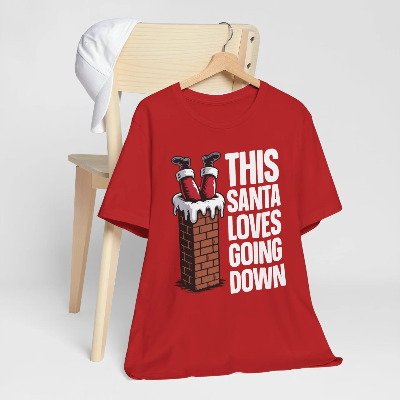 This Santa Loves Going Down T-Shirt showing Santa's boots sticking out of a chimney, a Funny Adult Naughty Christmas Shirt design.