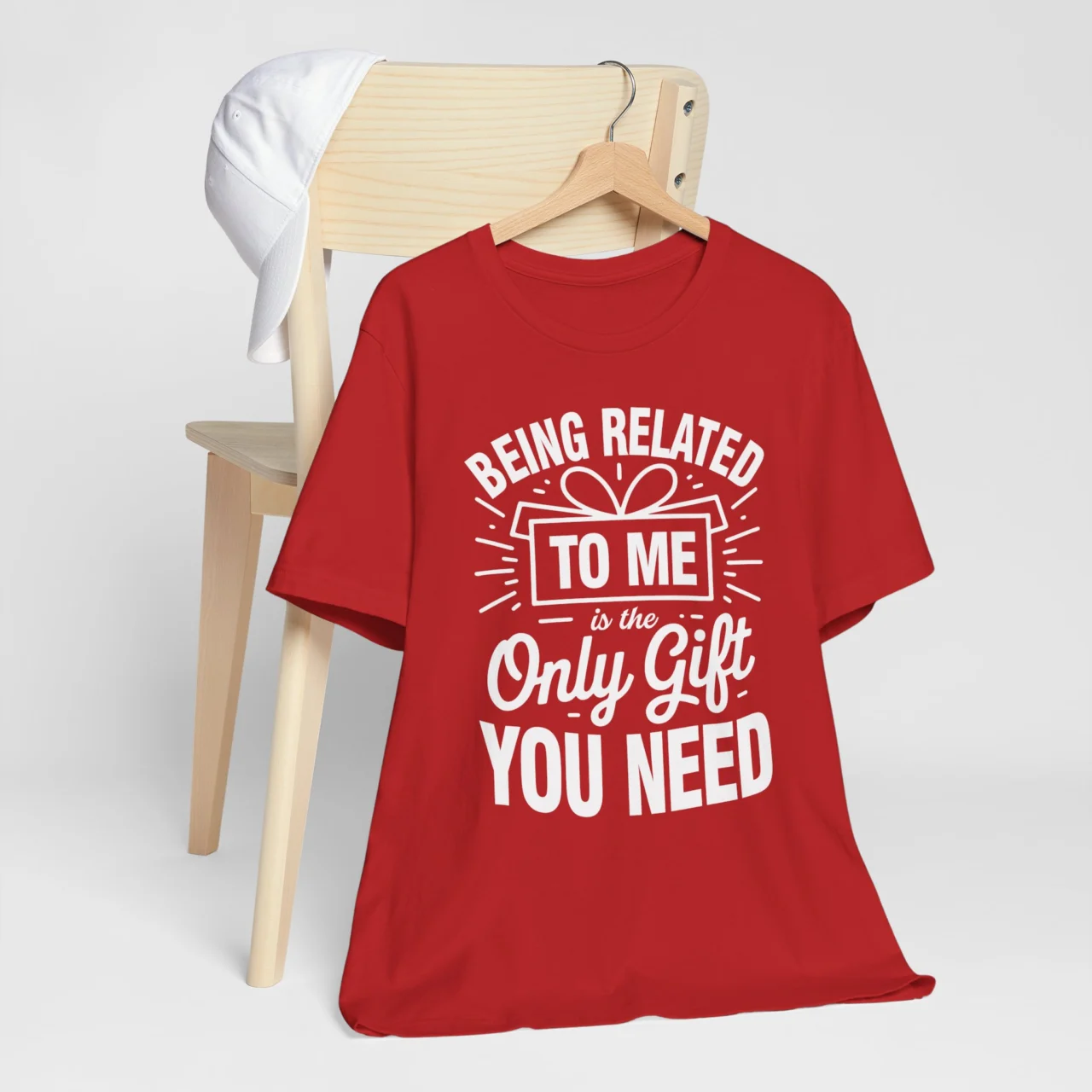 Being Related To Me Is The Only Gift You Need Shirt in white festive text with a gift box icon on a red t-shirt, a Funny Sarcastic Family Christmas Tee design.