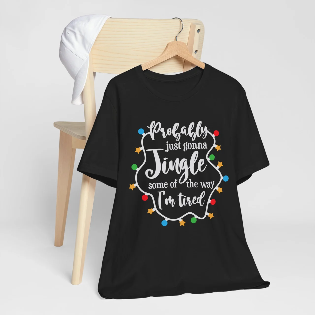 Just Gonna Jingle Shirt in white script with colorful string lights, a Funny Tired Sarcastic Christmas Tee design.